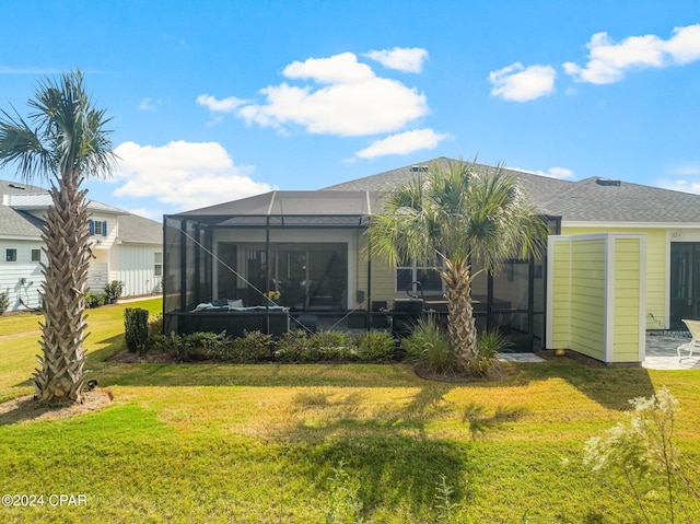 rear view of property with a lawn and a lanai