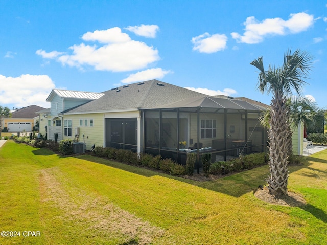 back of property with a lawn, central AC unit, and a lanai