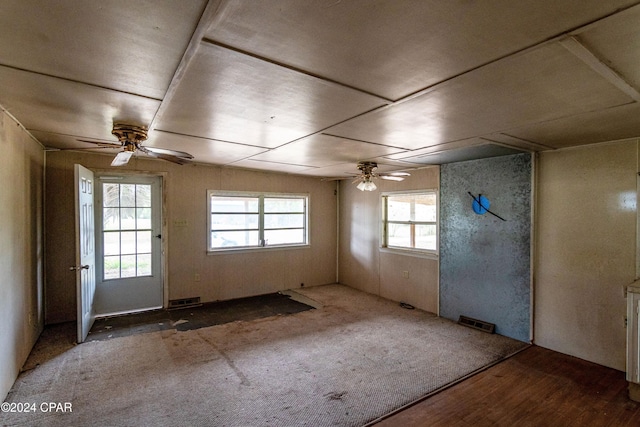 spare room featuring wood-type flooring, ceiling fan, and plenty of natural light