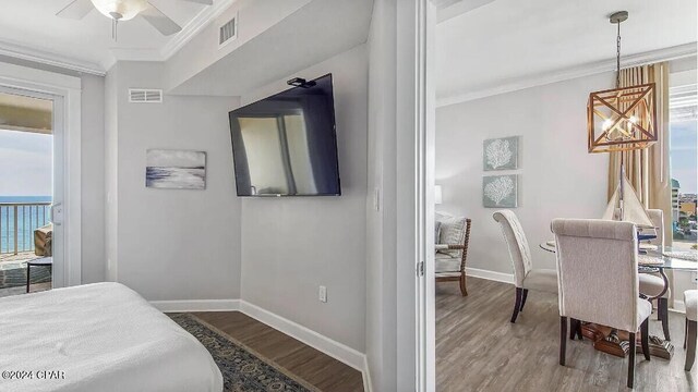 bedroom with wood-type flooring, multiple windows, and ceiling fan with notable chandelier