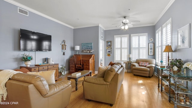 living room featuring ornamental molding, light wood-type flooring, and ceiling fan