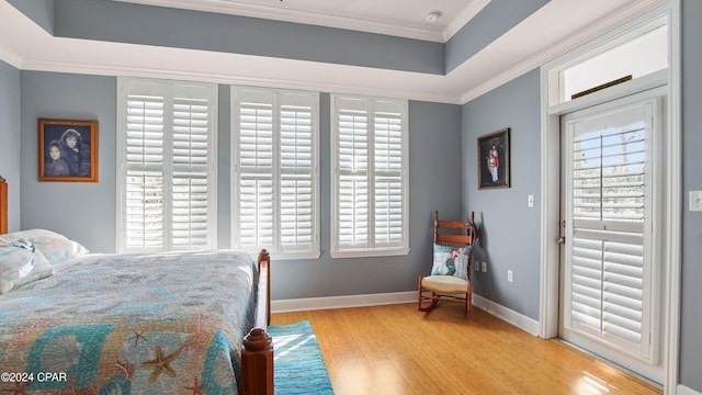 bedroom featuring ornamental molding, light hardwood / wood-style flooring, and multiple windows