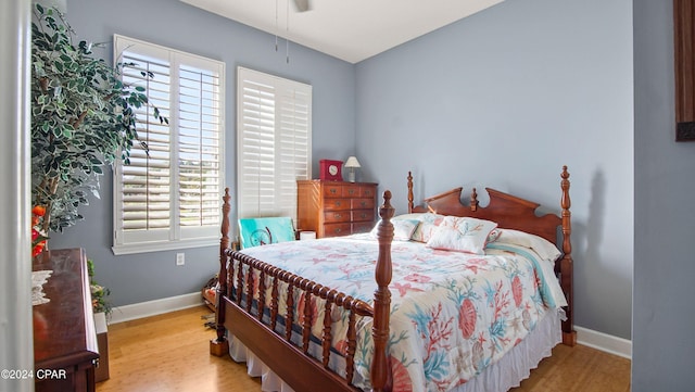 bedroom with hardwood / wood-style floors and multiple windows