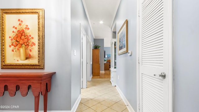 hall with light tile patterned floors and ornamental molding