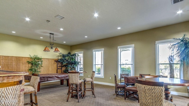 carpeted dining space with a textured ceiling