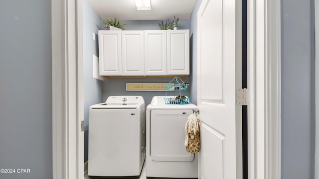 laundry room featuring separate washer and dryer and cabinets