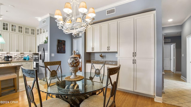 dining room featuring light hardwood / wood-style floors, a notable chandelier, and ornamental molding