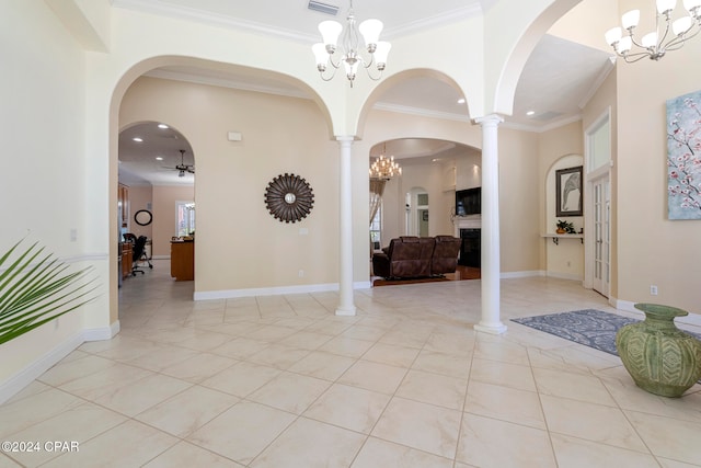 entrance foyer featuring decorative columns, ceiling fan with notable chandelier, light tile patterned floors, and crown molding