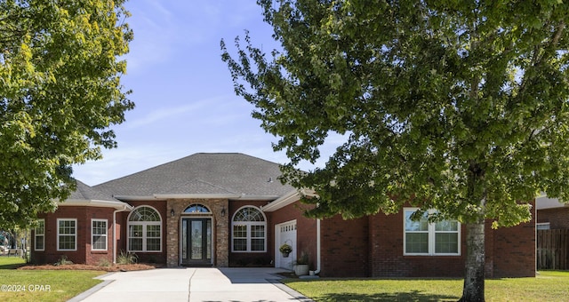 view of front of house with a garage and a front lawn