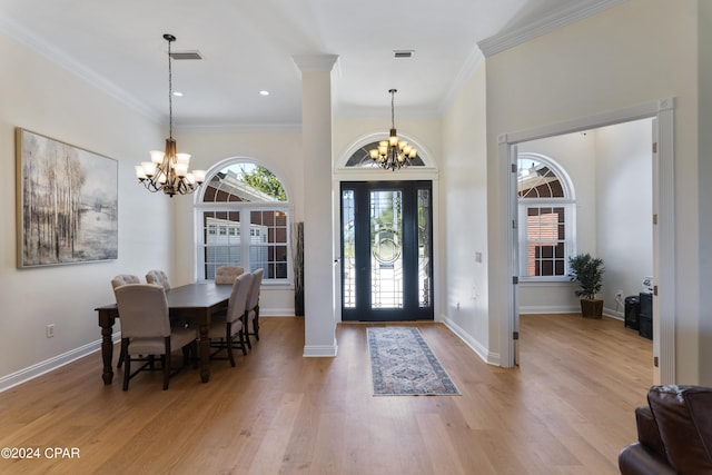 foyer entrance with light hardwood / wood-style flooring, a chandelier, and ornamental molding