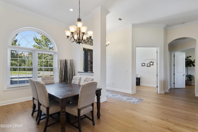 dining space with an inviting chandelier, ornamental molding, and light wood-type flooring