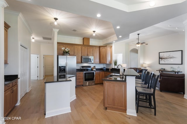 kitchen featuring kitchen peninsula, sink, light wood-type flooring, and appliances with stainless steel finishes