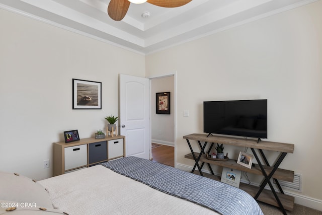 bedroom with a raised ceiling and ceiling fan