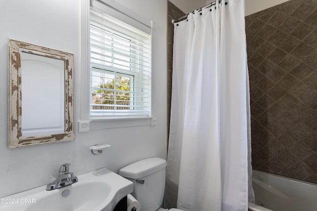 full bathroom with sink, shower / tub combo, and toilet