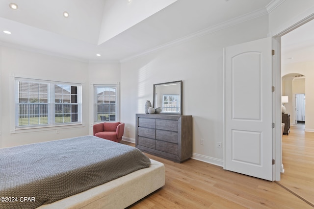 bedroom featuring multiple windows, light hardwood / wood-style floors, and ornamental molding