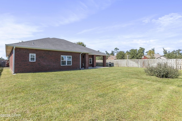 rear view of property with a yard and a patio area