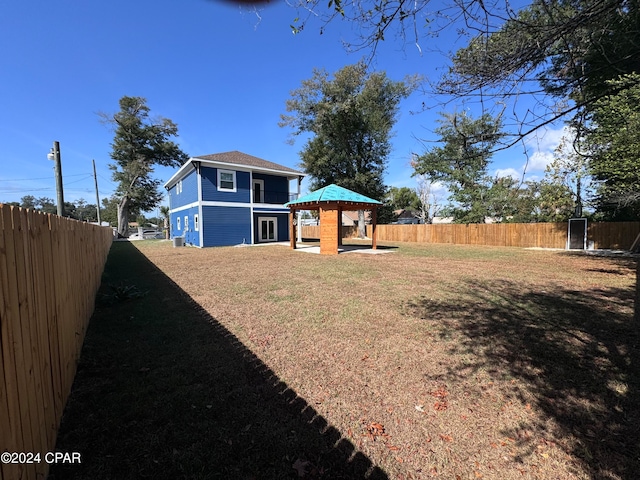 back of house with a gazebo and a lawn