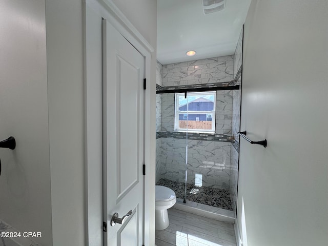 bathroom with toilet and a shower with shower door