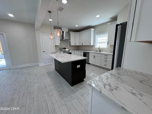 kitchen with white cabinets, a kitchen island, stainless steel range with electric stovetop, wall chimney exhaust hood, and sink