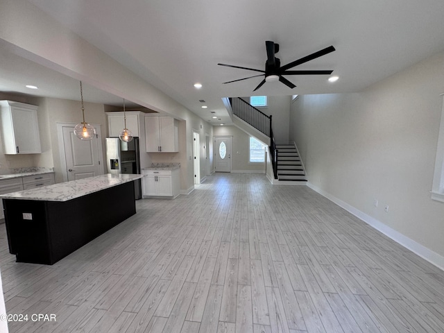 kitchen featuring a kitchen island, white cabinetry, pendant lighting, and light hardwood / wood-style floors