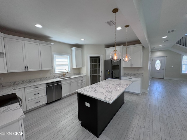 kitchen with white cabinetry, stainless steel appliances, decorative light fixtures, and a kitchen island