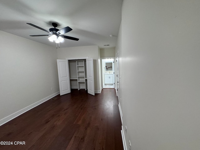 unfurnished bedroom with a closet, dark hardwood / wood-style floors, and ceiling fan