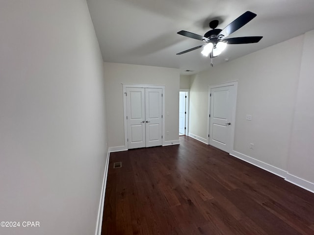 unfurnished bedroom with dark wood-type flooring and ceiling fan