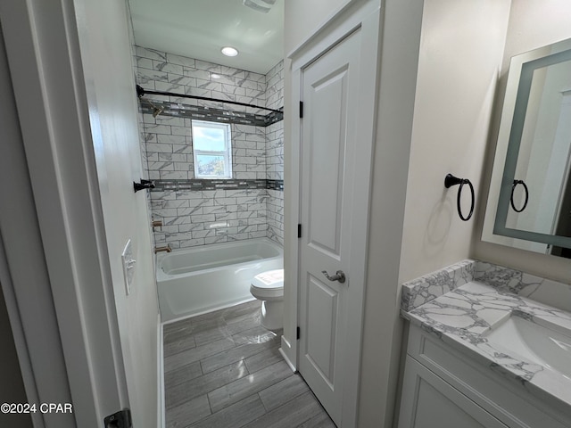 full bathroom featuring toilet, tiled shower / bath, and vanity