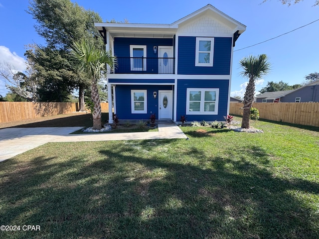 view of front of property featuring a balcony and a front lawn