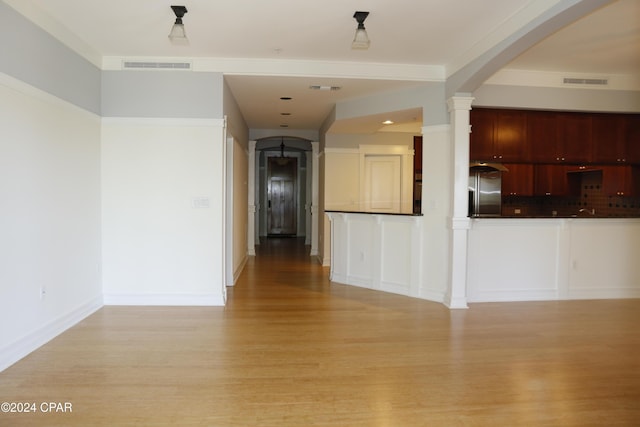 interior space featuring ornate columns and light wood-type flooring