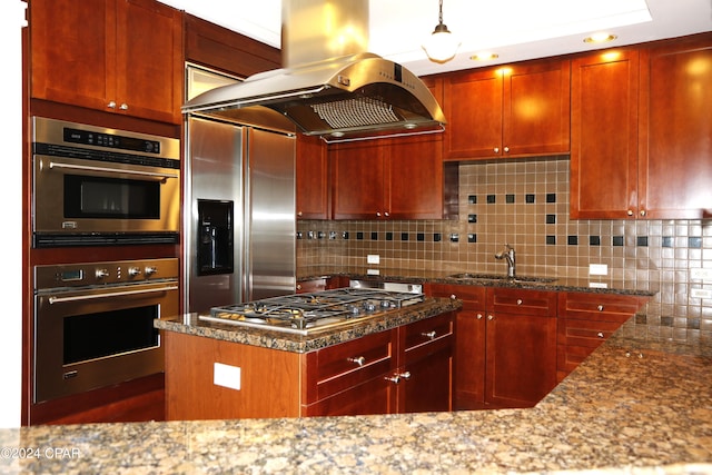 kitchen with sink, appliances with stainless steel finishes, stone counters, island exhaust hood, and decorative backsplash