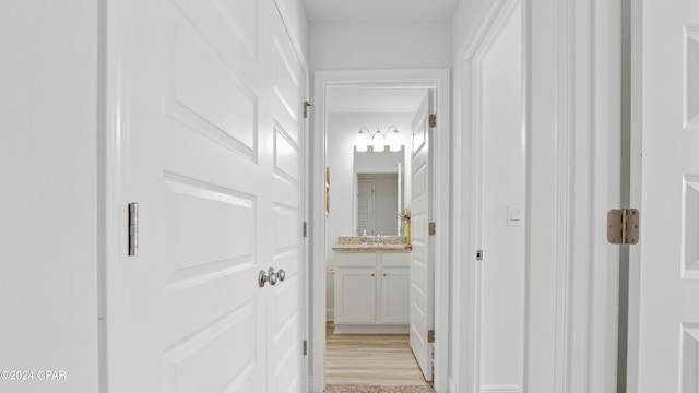 hallway with sink and light hardwood / wood-style flooring