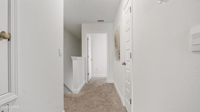 hallway featuring light colored carpet