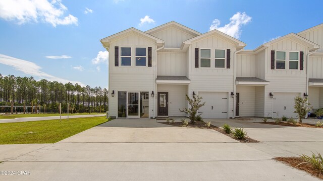 view of property featuring a garage and a front yard