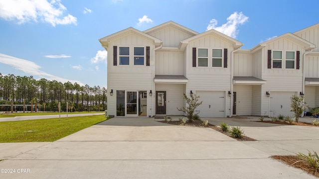 view of property featuring a front yard and a garage