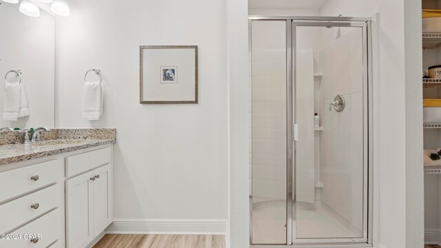 bathroom featuring vanity, hardwood / wood-style flooring, and walk in shower