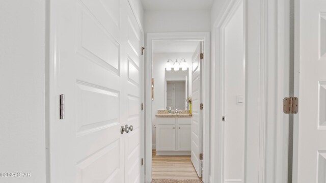 hall with light hardwood / wood-style flooring and sink