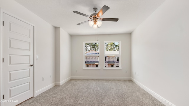 empty room with light colored carpet and ceiling fan