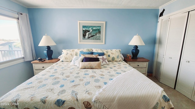 bedroom featuring ornamental molding, a closet, a textured ceiling, and carpet