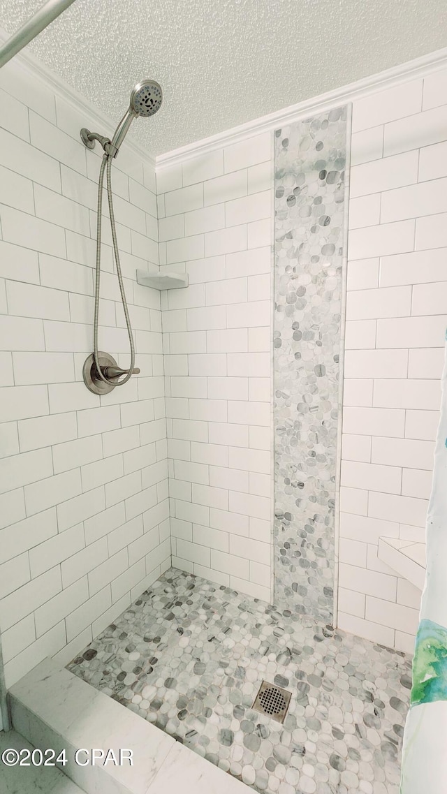 bathroom with a textured ceiling and walk in shower