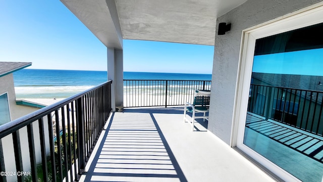 balcony with a water view and a beach view