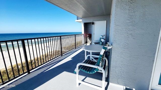 balcony featuring a water view and a beach view