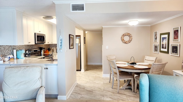 dining space with crown molding, a textured ceiling, and sink