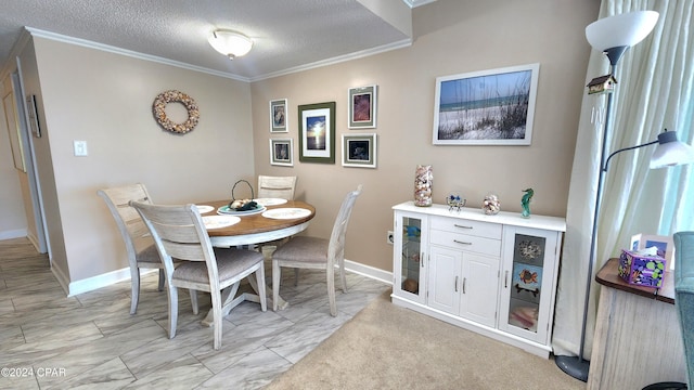 dining space with a textured ceiling, ornamental molding, and light colored carpet