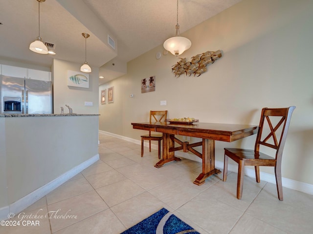 dining space with light tile patterned floors and a textured ceiling