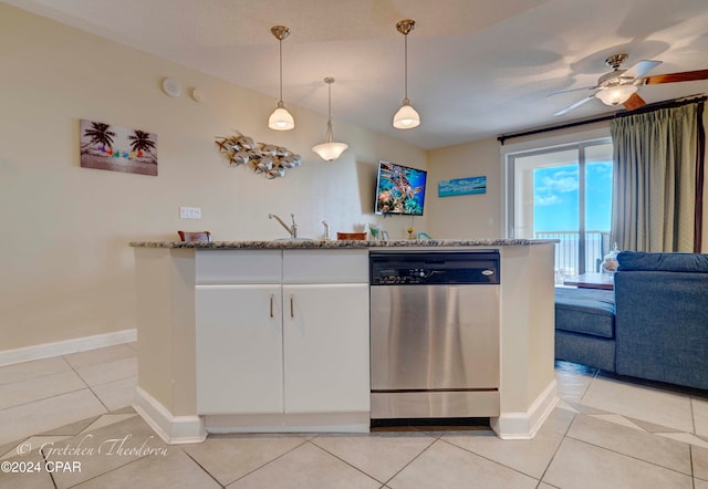 kitchen with stainless steel dishwasher, light tile patterned floors, decorative light fixtures, light stone counters, and white cabinetry