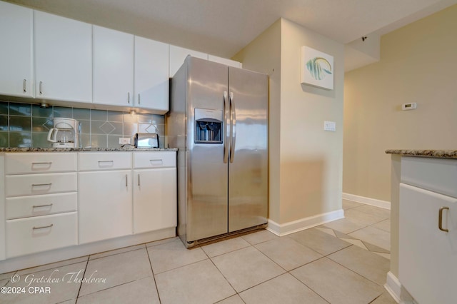 kitchen with white cabinets, stainless steel fridge with ice dispenser, backsplash, and stone countertops