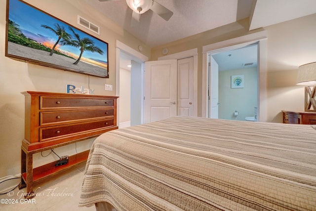 bedroom with tile patterned floors, ceiling fan, and a closet