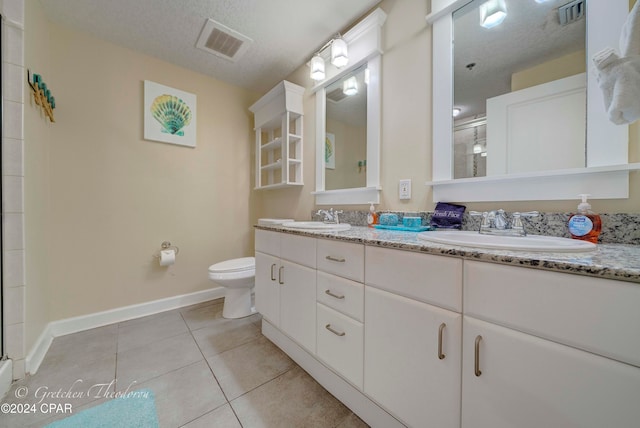 bathroom featuring vanity, tile patterned floors, toilet, a textured ceiling, and walk in shower