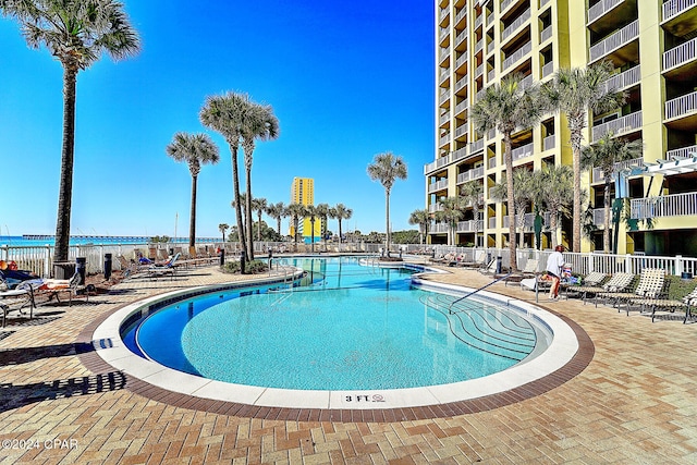 view of pool with a patio area and a water view